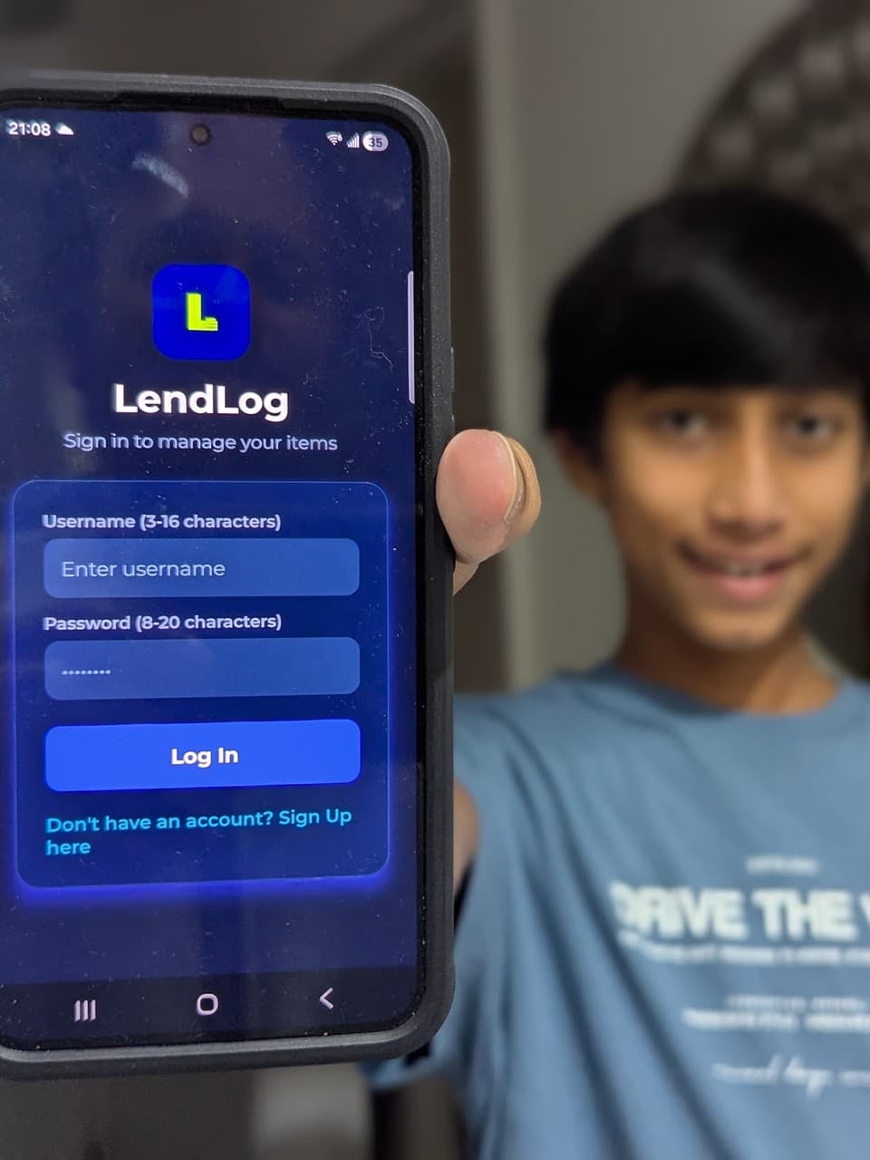 Saad, a PsyntaxLabs Academy student, holding up his phone showing LendLog, the app he built