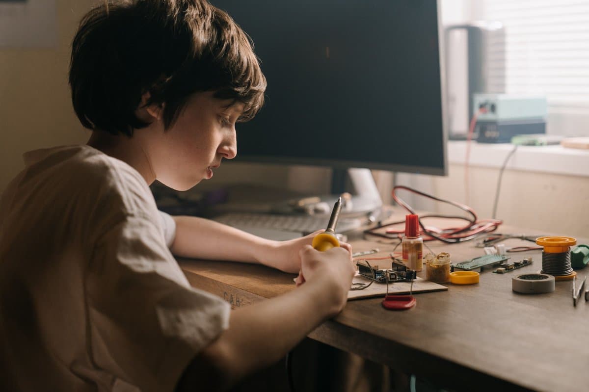 A student building electronics hands-on at a workbench