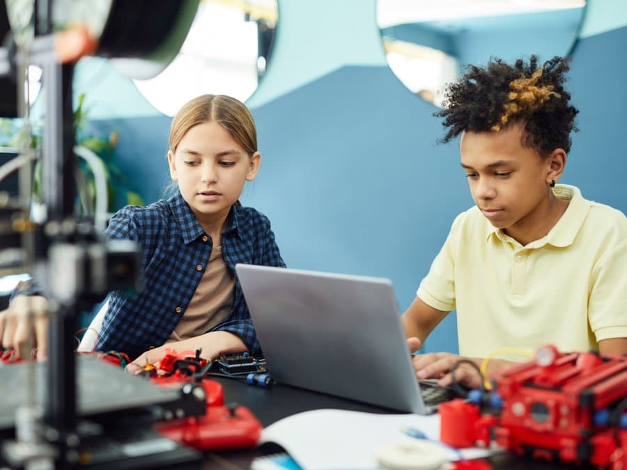 Two students building an AI-powered robot at PsyntaxLabs Academy